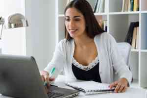 mulher muito jovem trabalhando com laptop em seu escritorio 1301 4268