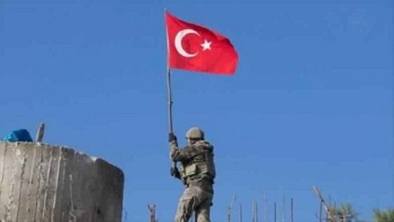 جندي يرفع العلم التركي على الأراضي السورية بعد السيطرة عليها