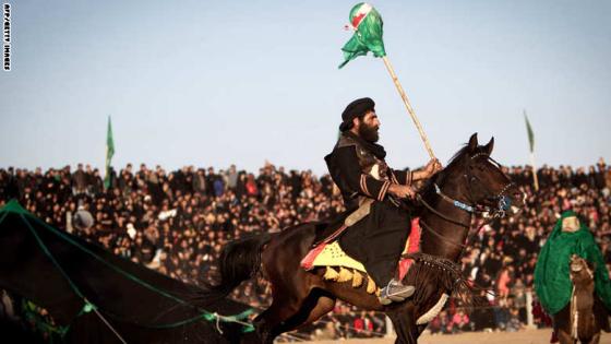 An Iranian Muslim Shiite man, impersonating the role of an enemy of Prophet Mohammed's grandson Imam Hussein, holds the head of Hussein on his spear during the annual religious performance of "Tazieh" in the Iranian town of Noosh Abad near the central city of Kashan, on November 15, 2013, marking the mourning period of Ashura which commemorates the killing of Prophet Mohammed's grandson Imam Hussein. Across the country, ritual processions as well as Tazieh, or street performances re-enacting the events of Karbala, and narrative poems, tell the story of Hussein's martyrdom and how he stood his ground against the tyrant. AFP PHOTO/BEHROUZ MEHRI (Photo credit should read BEHROUZ MEHRI/AFP/Getty Images)